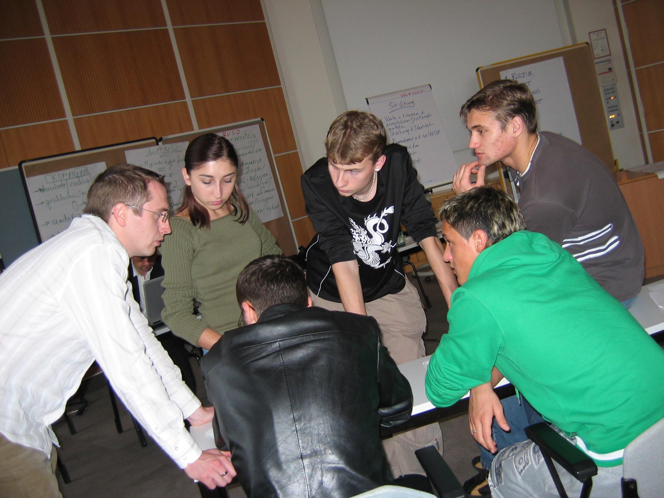 mehrere Jugendliche konzentriert an einem Tisch