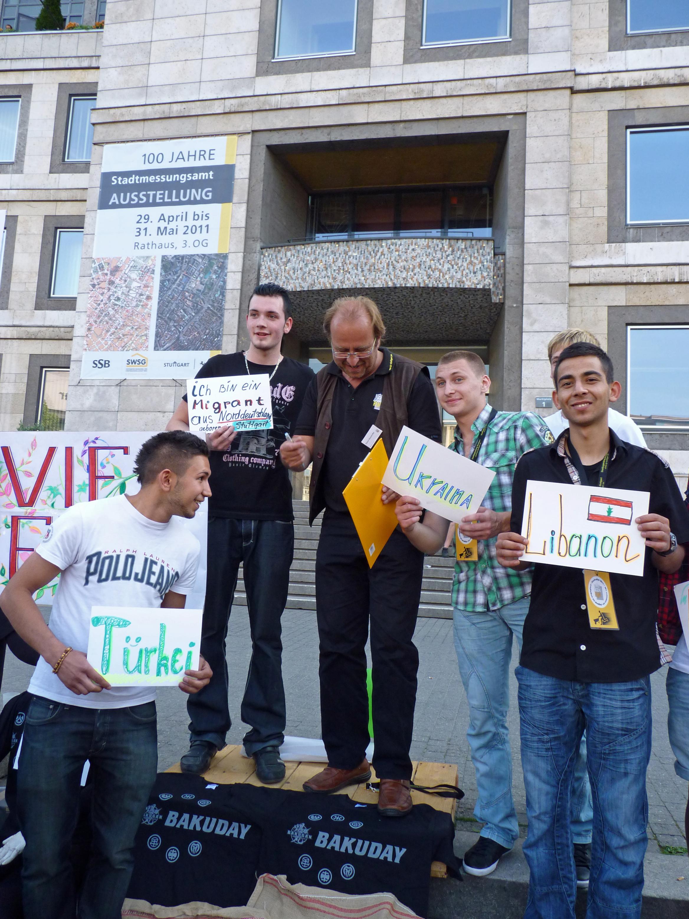 Jugendliche mit Schildern ihres Herkunftslandes vor dem Rathaus