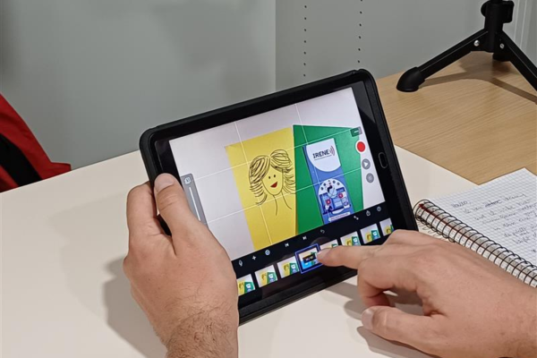 Auf einem Tablett, das von zwei Händen gehalten wird, werden Grafiken angezeigt. 