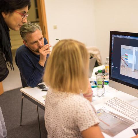 Junge Frau sitzt am Bildschirm