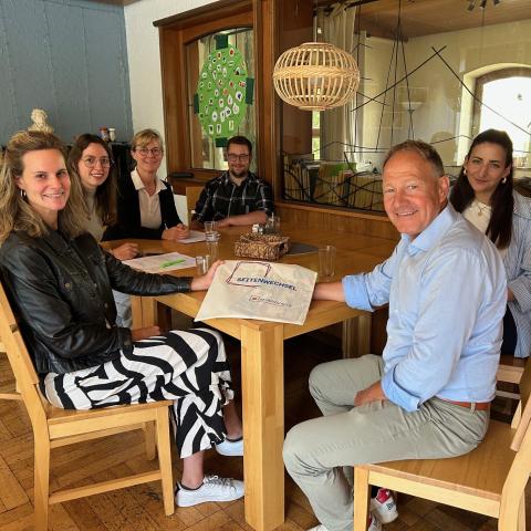 Menschen rum um einen Tisch sitzend