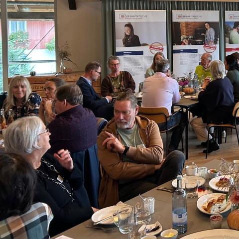Menschen an Tischen beim Frühstück