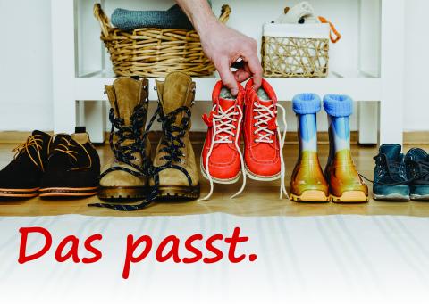 eine bunte Reihe an Schuhen, in die ein Schuhpaar hinzugestellt wird