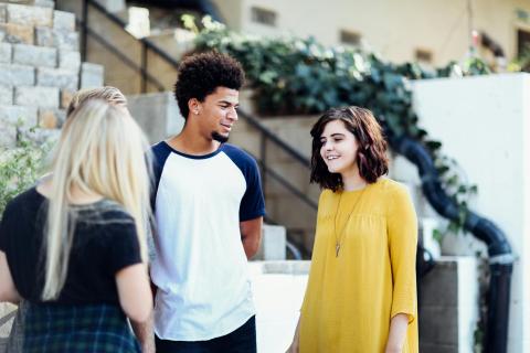 three young persons talking outside