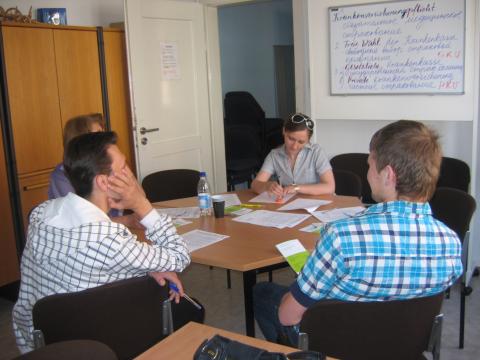 mehrere Menschen in einem Büro um einen runden Tisch