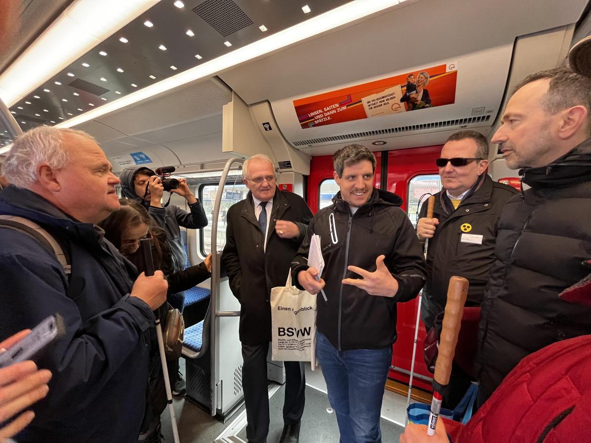 Eine Gruppe von diskutierenden Menschen stehend in der S-Bahn