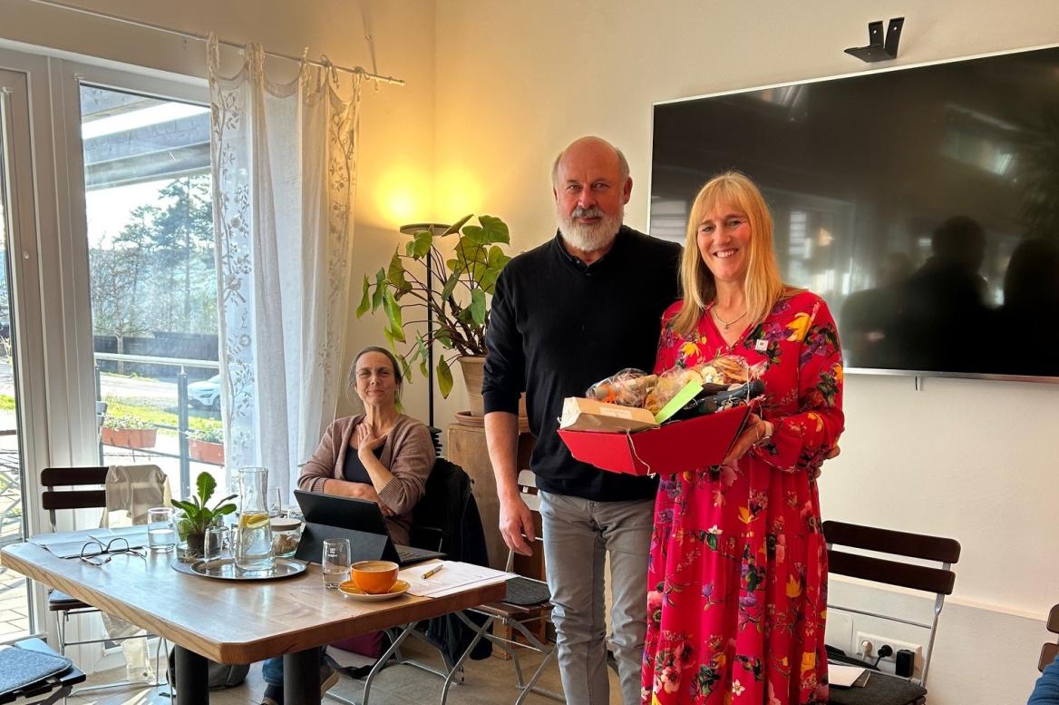 Renate Hold verabschiedet ihren Vorstandskollegen Norbert Bruder aus dem Ehrenamt Mann und Frau mit Geschenkkorb