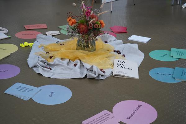 Notizzettel auf dem Boden, eine Blumenvase in der Mitte