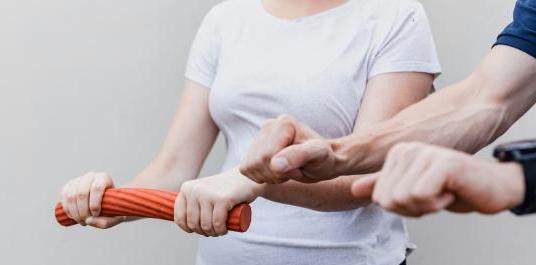 Person mit Hanteln und Strechband