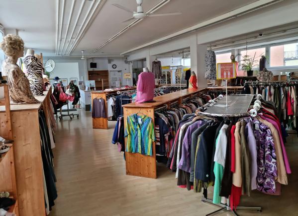 Blick in einen Bekleidungsgeschäft, mit Ständern mit Kleidern.