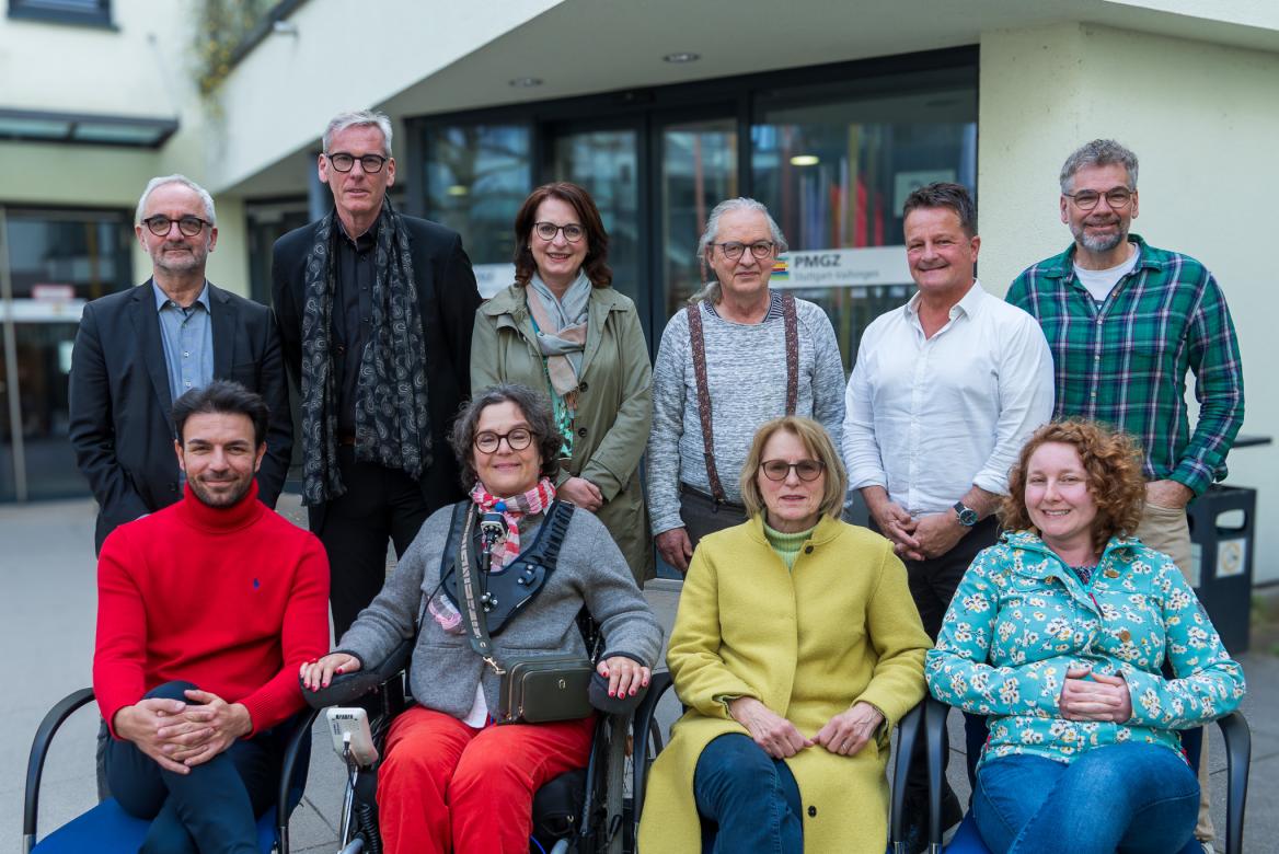 eine Gruppe von Menschen sitzt und steht vor einem Gebäude