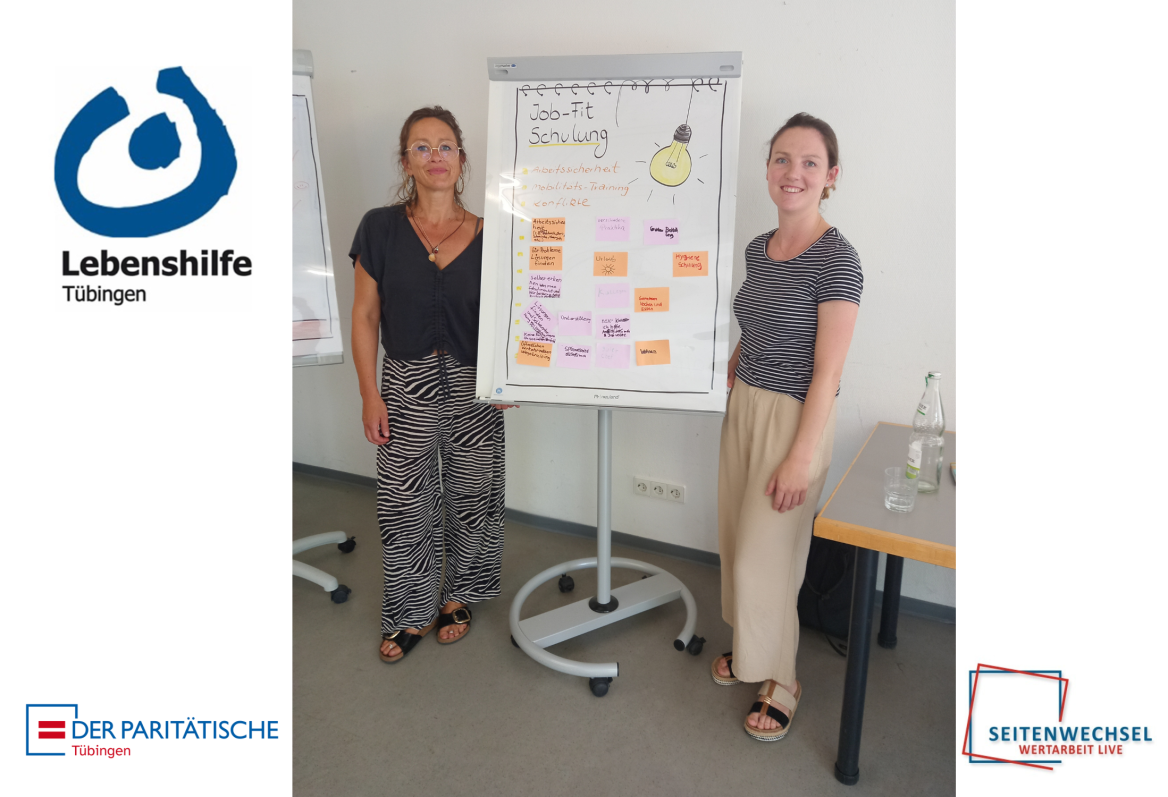 zwei Mitarbeiter*innen von Job Fit vor einem Plakat