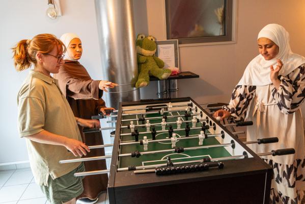 3 junge Frauen spielen Tischkicker
