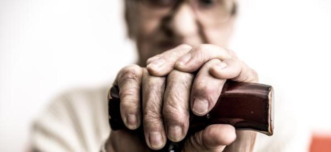 Senior stützt sich auf Gehstock