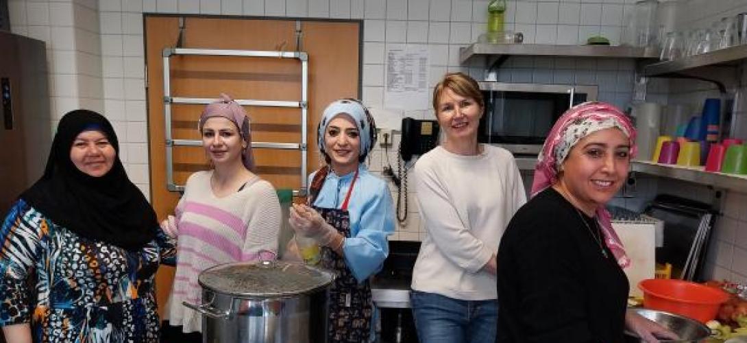 mehrere Frauen in einer Küche mit großen Töpfen