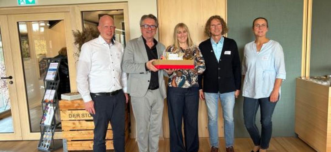 drei Männer und zwei Frauen mit Geschenkkarton
