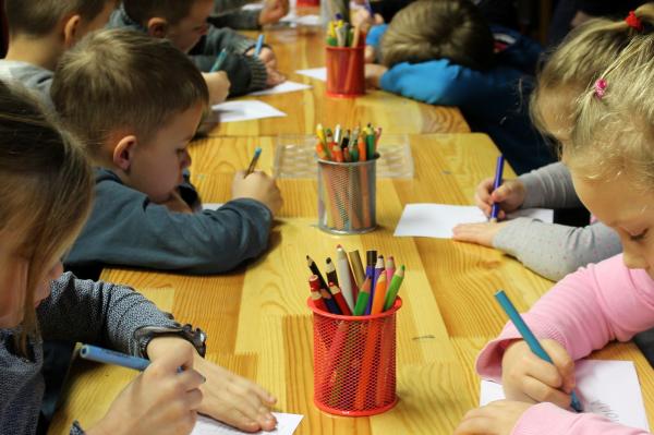 Kinder malend am Tisch in der Kita