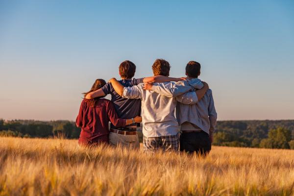 Drei junge Männer und eine Frau stehen im Kornfeld