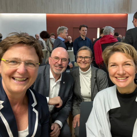 vier Menschen lachen in die Kamera