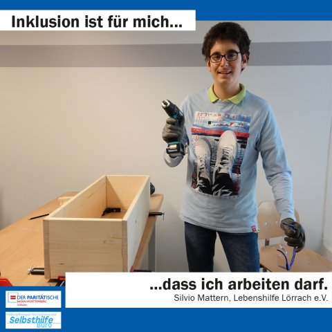 Ein junger Mann mit Schutzbrille steht mit einem Akkubohrer in der Hand vor seinem Werkstück. Darunter steht: "Inklusion ist für mich dass ich arbeiten darf. Silvio Mattern, Lebenshilfe Lörrach e.V."