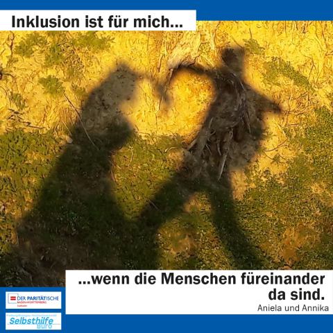 Der Schatten zweier Menschen bildet ein Herz. Darunter steht: "Inklusion ist füür mich wenn die Menschen füreinander da sind. Aniela und Annika"