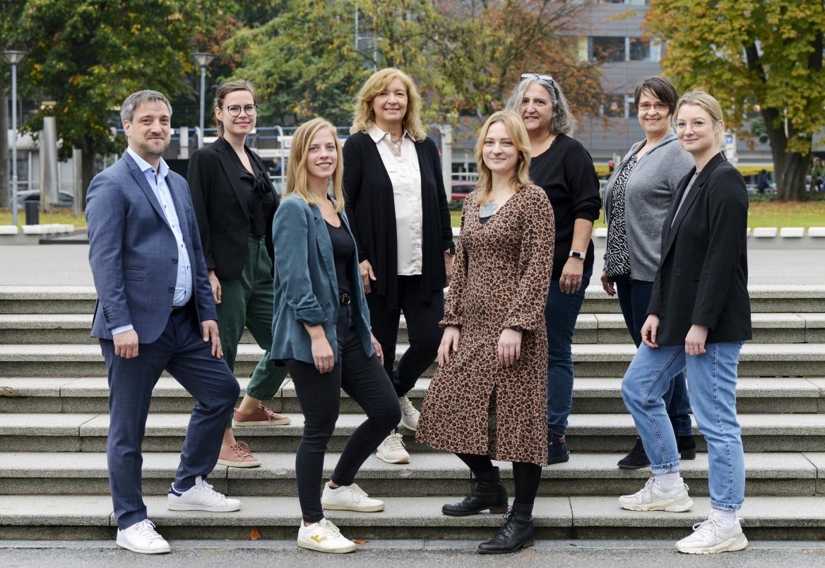 Gruppenfoto des 8-köpfigen Teams der KISS Stuttgart, die nebeneinander auf einer Treppe stehen.