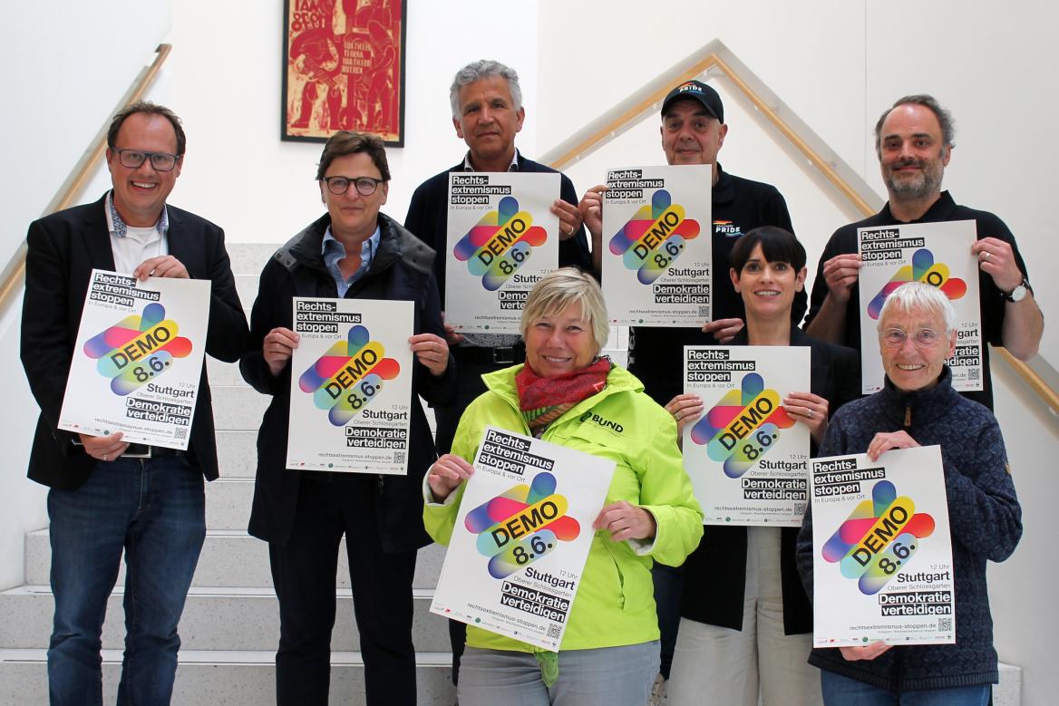 Frauen und M&auml;nner stehen hintereinander auf der Treppe mit Plakaten in der Hand