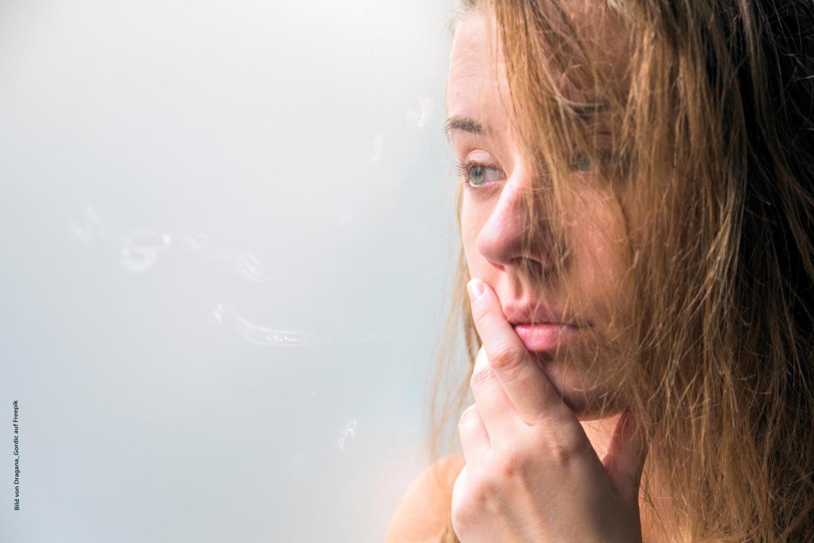 Frau mit dunkelblonden Haaren mit Hand am Mund