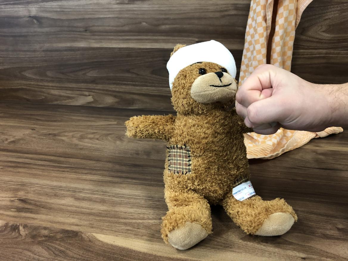 Verletzter Teddyb&auml;r mit vebundemKopf und Pflaster auf dem Oberschenkel
