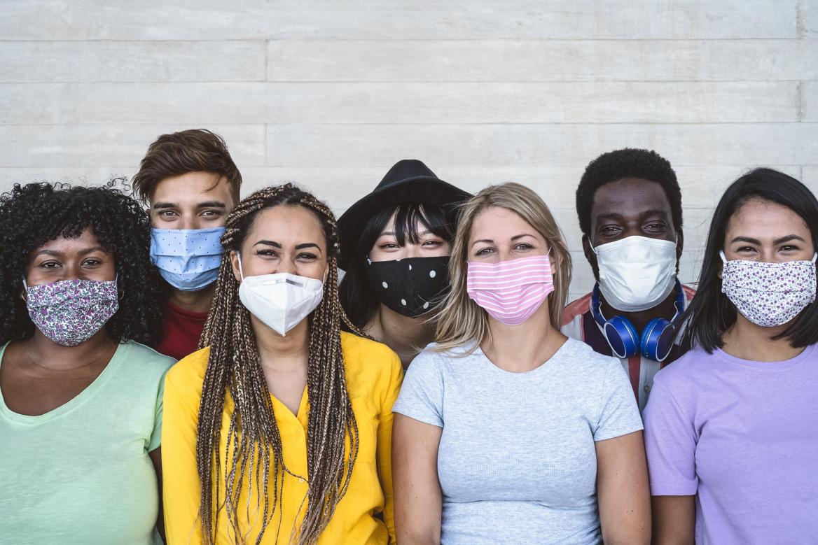 Jungs und M&auml;dchen mit Maske stehen in einer Reihe