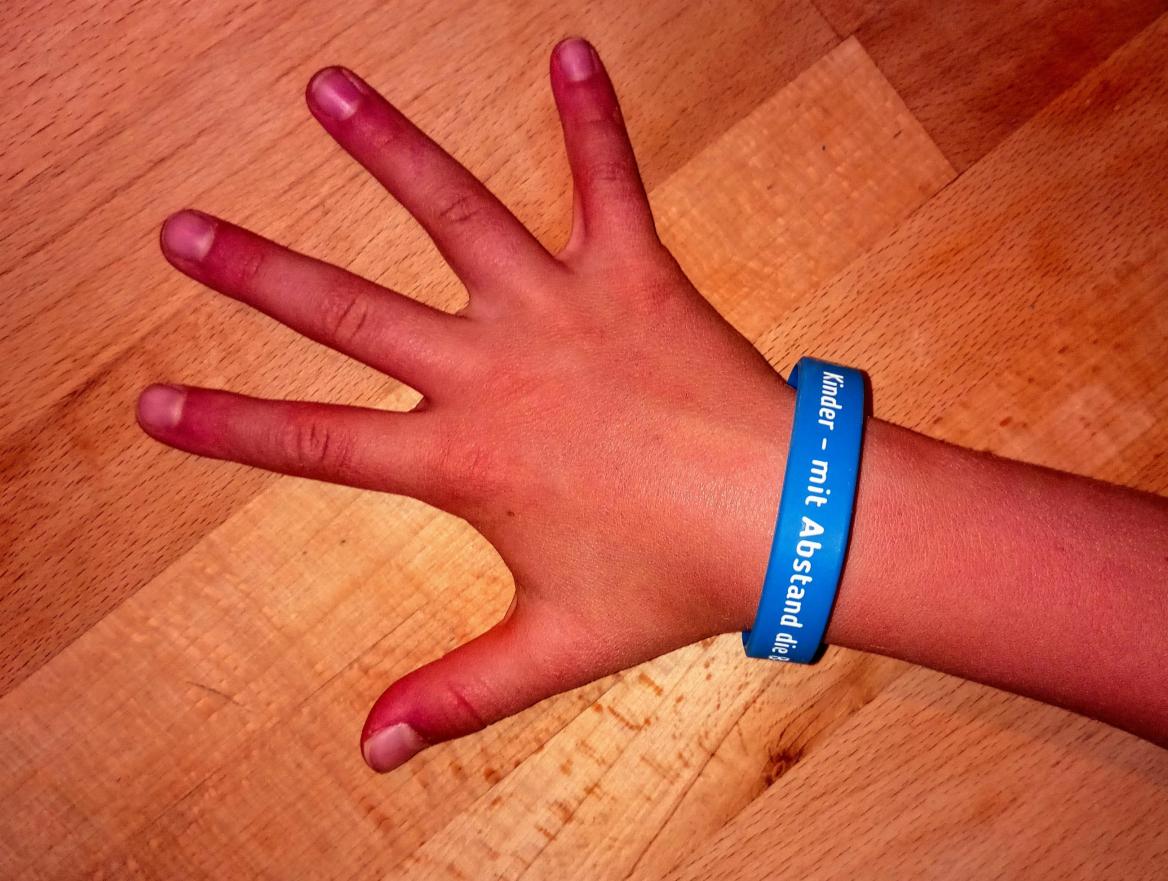 Kinderhand mit Armband "Kinder mit Abstand die Besten"