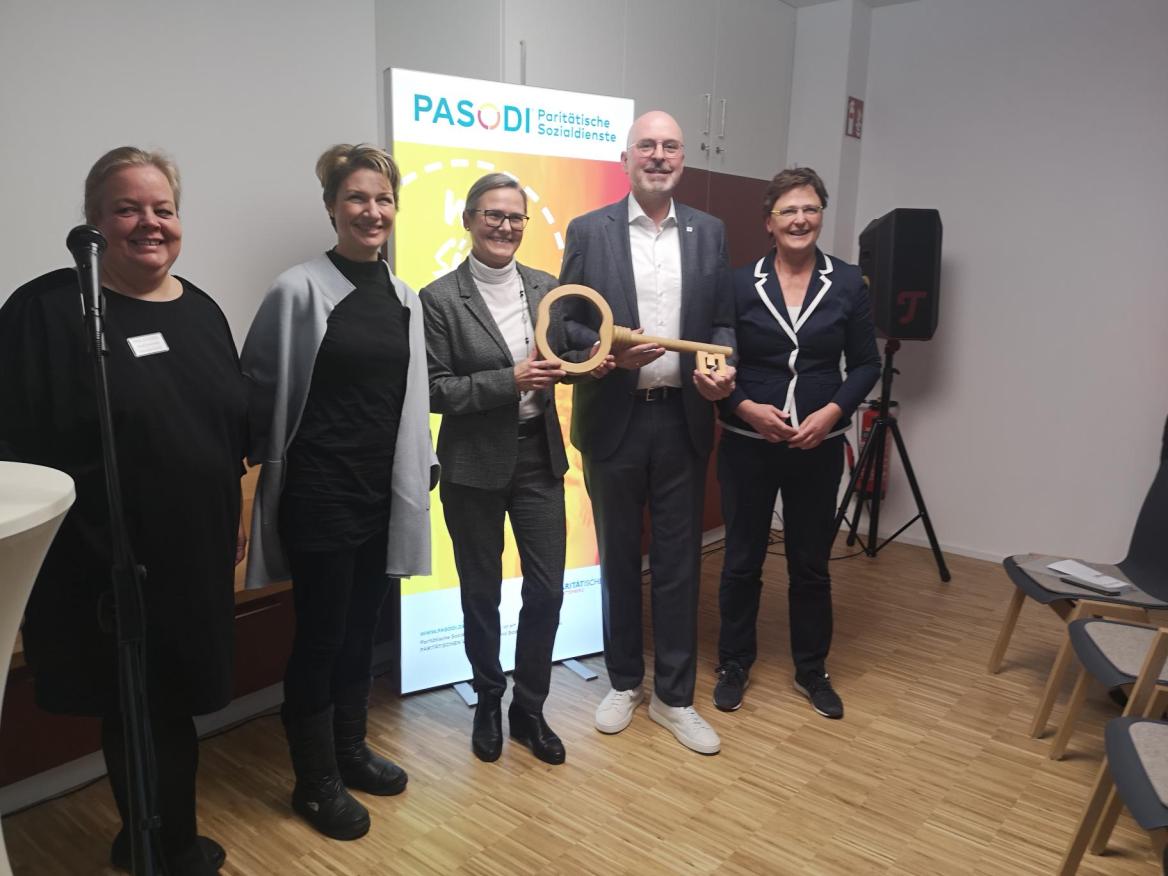 Eine Gruppe von Menschen mit einem &uuml;bergro&szlig;en Schl&uuml;ssel in den H&auml;nden