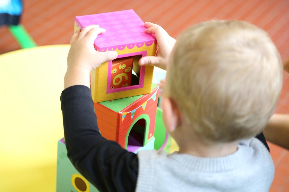 Kind von hinten mit Spielzeug