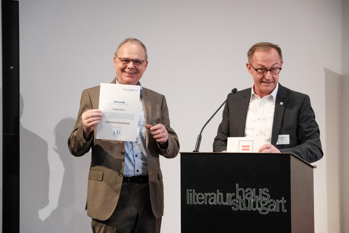 Herr M&uuml;ller und Herr Hartmann am Rednerpult. Herr M&uuml;ller zeigt seine Ehrenurkunde